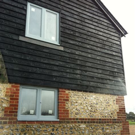 Black Barn Board Cladding With Brick And Flint