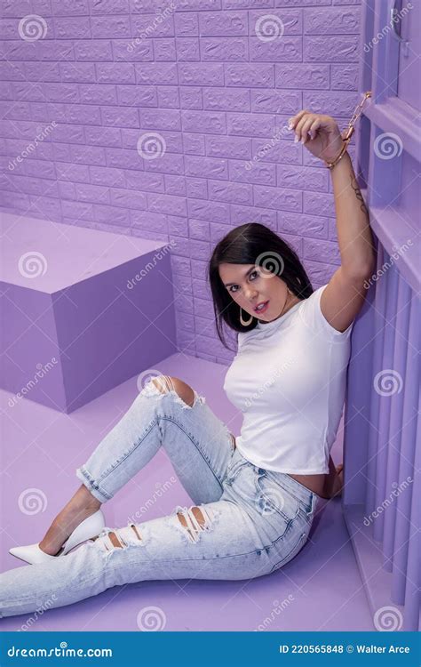 A Lovely Brunette Model Sits In A Lavender Jail Waiting To Plead Her