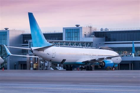 Avião de passageiros estacionado no terminal no pátio matinal do