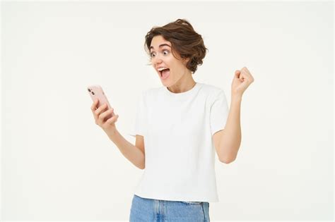Free Photo Portrait Of Excited Brunette Woman With Smartphone Looking At Mobile Phone Screams