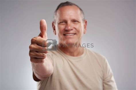 I Cant Not Like This A Handsome Mature Man Standing Against A Grey Background In The Studio And