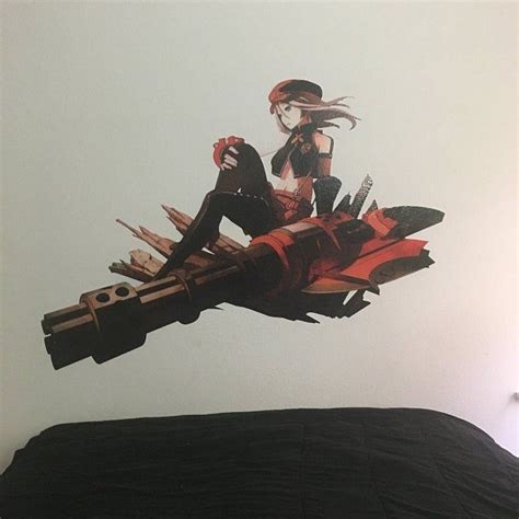 A Woman Sitting On Top Of A Bed In Front Of A Wall Sticker With An