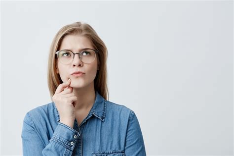 Portrait isolé de jeune fille blonde élégante en chemise en jean et
