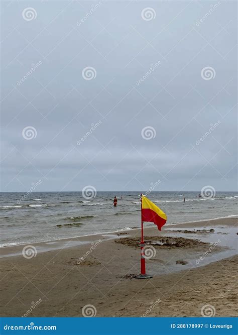 A Yellow and Red Beach Flag, Warning Flag, Lifesaving Surf Flag, Rainy