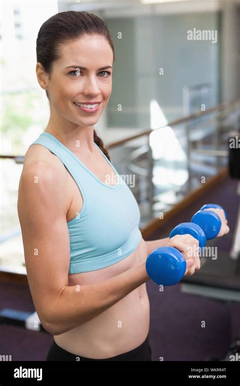 Fit Brunette Lifting Blue Dumbbells At The Gym Stock Photo Alamy