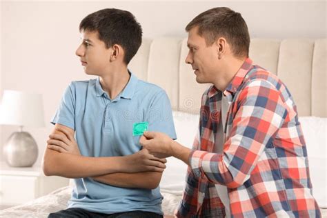 Father Giving Condom To His Teenage Son In Bedroom Sex Education Concept Stock Image Image Of