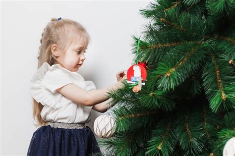 Jeune fille blonde décorer le sapin de Noël Photo Gratuite