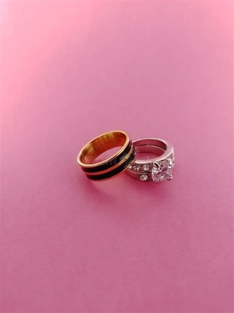 Two Beautiful Gold And Silver Wedding Rings Isolated On A Pink