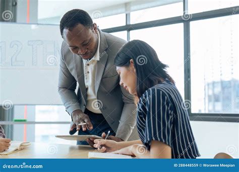 Mature Professor Talking To His Student While Assisting Her On A Class At The University Stock