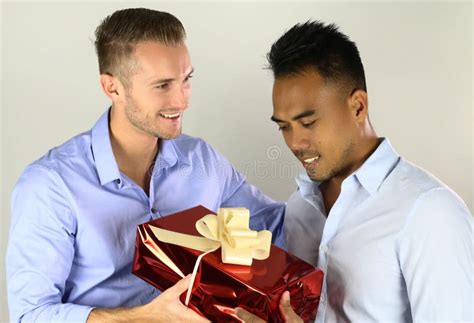 Dos Pares Gay De Los Hombres Que Intercambian Un Presente Imagen De Archivo Imagen De Mezclado