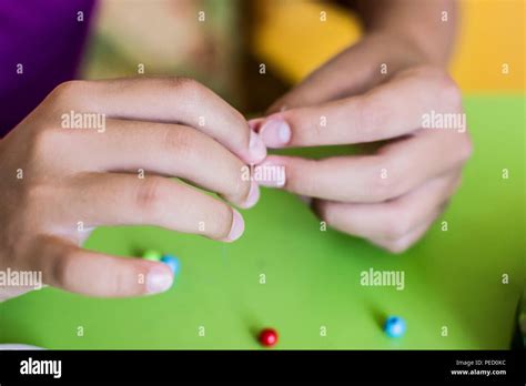 Girls Hand Stringing Beads On A String Stock Photo Alamy