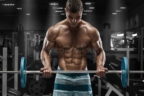 Muscular Man Working Out In Gym Doing Exercises With Barbell Strong Male Naked Torso Abs Stock
