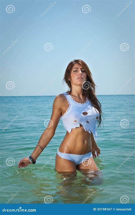 Junges Sexy Brunettemädchen Im Weißen Bikini Und Nassen Im T Shirt Im Wasser Spielt