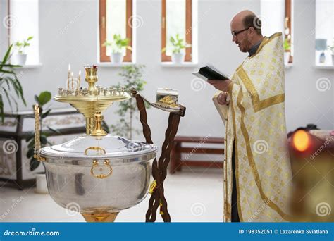 Baptism Of The Child. The Priest Reads A Prayer To The Godparents With ...