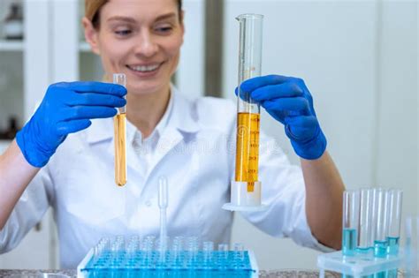 Biologo Donna In Possesso Di Tubi Di Prova Con Liquido Giallo A Mani Nude Che Fanno Esperimenti