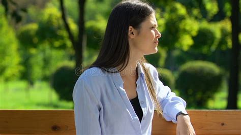Nervous Brunette Waiting For Friend On Bench In Park Looking Around Meeting Stock Footage