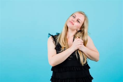 Une Fille Blonde Heureuse Souhaite Y Tenir La Main Sur L épaule Sur Fond Bleu Photo Gratuite