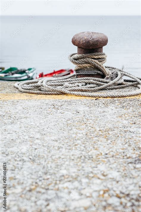 Antiguo Bolardo De Amarre Con Una Cuerda Atada En El Muelle Con Fondo