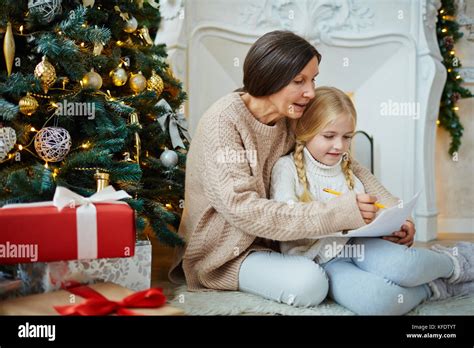 Mature Woman And Her Granddaughter Drawing Xmas Picture By Decorated Firtree Stock Photo Alamy