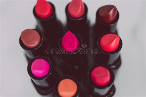 Group Of Red Pink And Nude Lipsticks With Different Colors And Textures In Circle On Marble