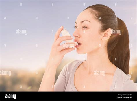 Composite Image Of Asthmatic Pretty Brunette Using Inhaler Stock Photo