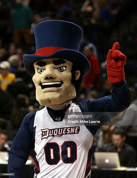 The Duquesne Dukes mascot walks on the court during a stoppage... News ...