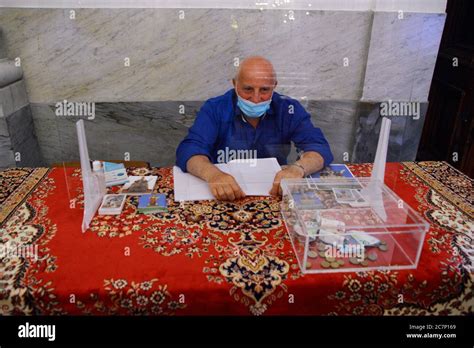 A Volunteer Who Collects The Offerings Of The Faithful With Mask And