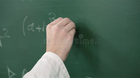 Hand Holding Chalk And Writing A Mathematical Formula Or Equation On