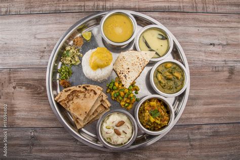 typical maharashtrian food served in a steal plate, marathi food includes kadhi and shrikhand ...