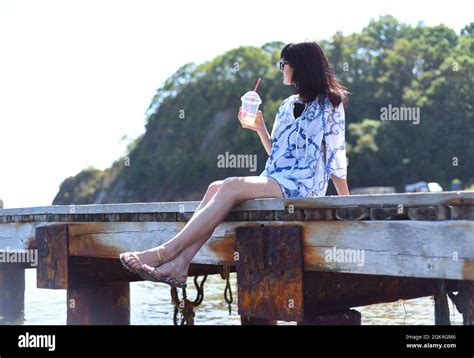 45 Years Old Russian Woman Drinking Lemonade And Sitting On Pier Stock