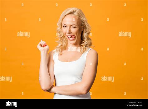 Happy Blonde Woman Showing Tongue While Looking At Camera Isolated On Orange Stock Photo Alamy