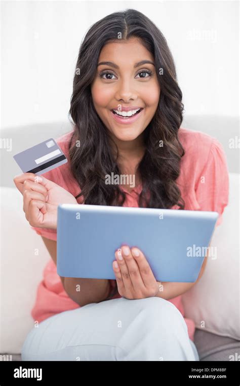 Happy Cute Brunette Sitting On Couch Holding Credit Card And Tablet Stock Photo Alamy