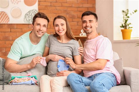 Gay Couple And Pregnant Woman With Baby Clothes At Home Stock Photo Adobe Stock