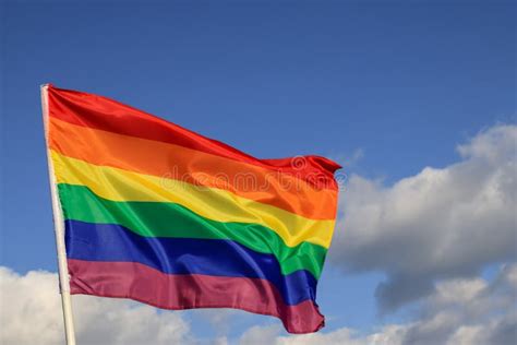 Acenando a Bandeira Do Arco íris Do Orgulho Gay Em Espaço Azul No Céu
