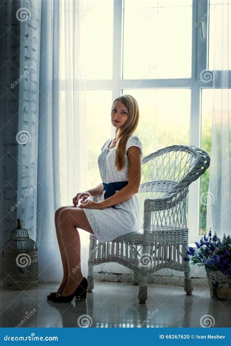 Pretty Brunette Wearing White Dress Posing On The Couch Stock Photo Image Of Elegance