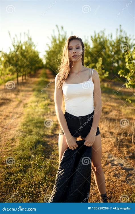 Beautiful Brunette Model Pose For Fashion Theme Shoot In The Middle Of Field With Grove Of Trees