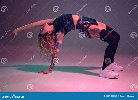 La Belle Fille Blonde Caucasienne Dans Des Shorts Bleus De Butin De Velours Et Des Bas Noirs