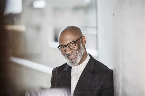 Portrait Of Smiling Mature Businessman With Grey Beard Wearing Glasses Stock Photo