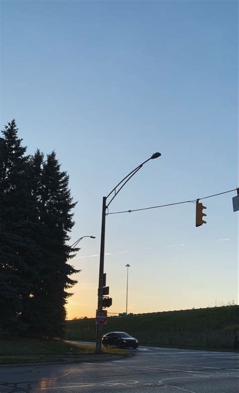 An Intersection With Traffic Lights And Trees In The Background