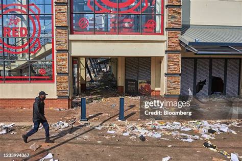 A Police Officer Passes The Jabulani Mall Following Rioting In The