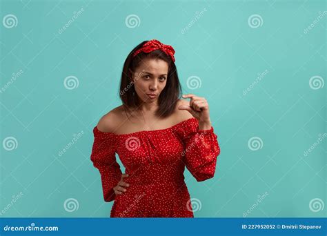 Een Mooie Europese Vrouw Brunette In Een Rode Jurk Met Blote Schouders Met Een Haarband Toont