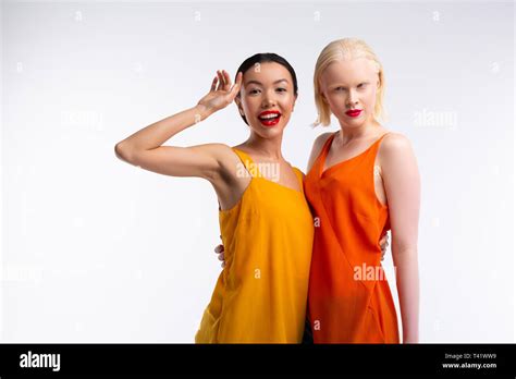 Blonde Haired Woman Hugging Her Beaming Friend With Red Lips Stock