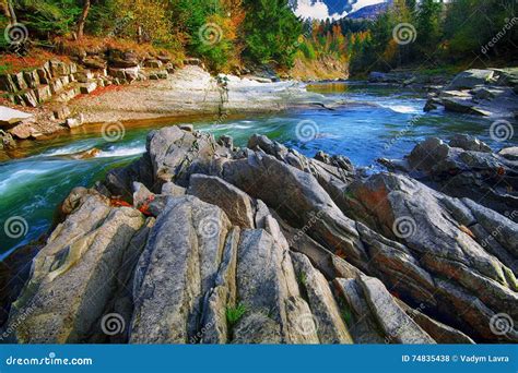 Mountain Fast Flowing River Stream Of Water In The Rocks At Autumn