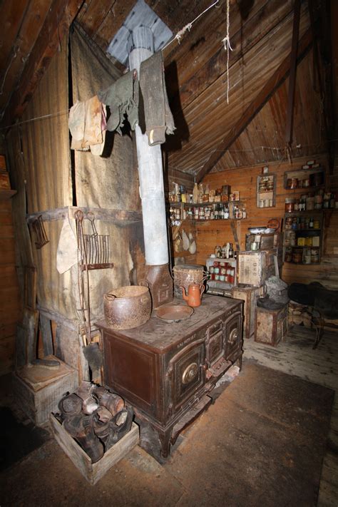 An Old Fashioned Stove In The Middle Of A Room With Wooden Walls And