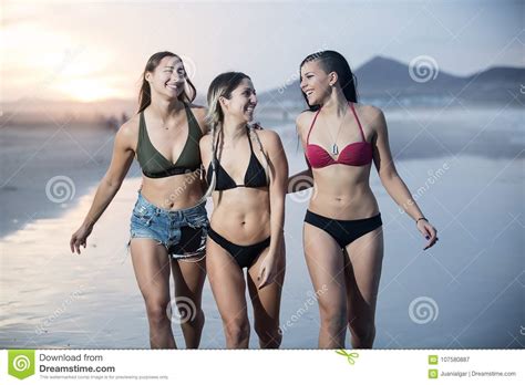 Mujeres Confiadas En Bikini Que Caminan En La Costa Imagen De Archivo