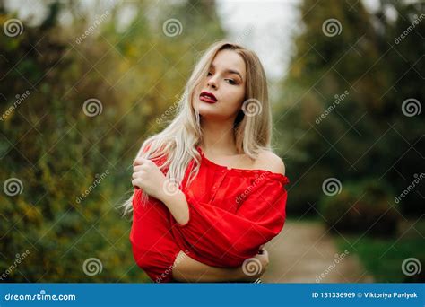 Gorgeous Blonde Woman In Red Blouse Posing With Naked Shoulder A Stock Image Image Of Park