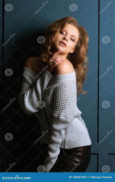 Studio Portrait Of Seductive Blonde Model With Fashion Makeup Wears Knitted Sweater Stock Image