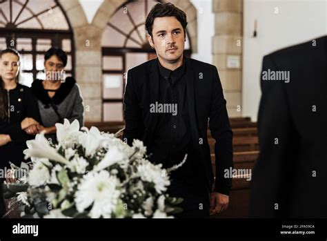 Funeral Death And Grief With A Man Pallbearer Carrying A Coffin In A