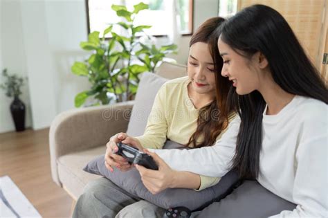 Asian Beautiful Lesbian Gay Couple Enjoy Play Game Together In Livingroom Two Female Friend Sit