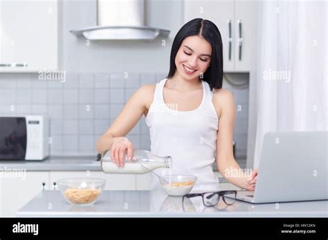 Brunette Woman Pouring Milk In Oak Flakes Stock Photo Alamy